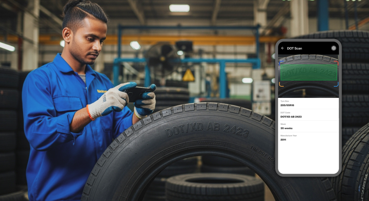 Technician using Scanflow’s AI tire scanner app to scan a DOT code from a tire sidewall inside an industrial facility. The smartphone screen displays the scanned tire details, including DOT code, size, and manufacture date.